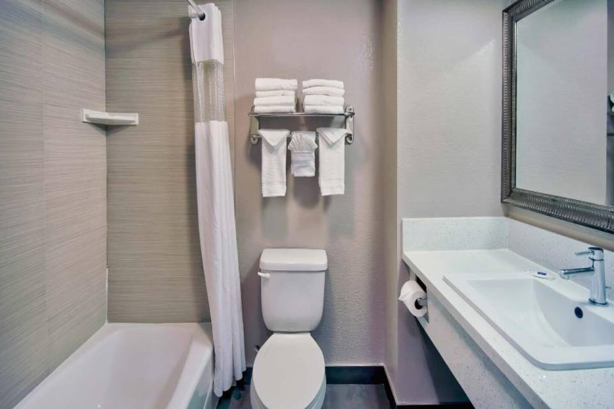 A bathroom with a bathtub, toilet, and sink.
