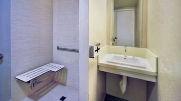 A bathroom with a shower, a toilet, and a sink.