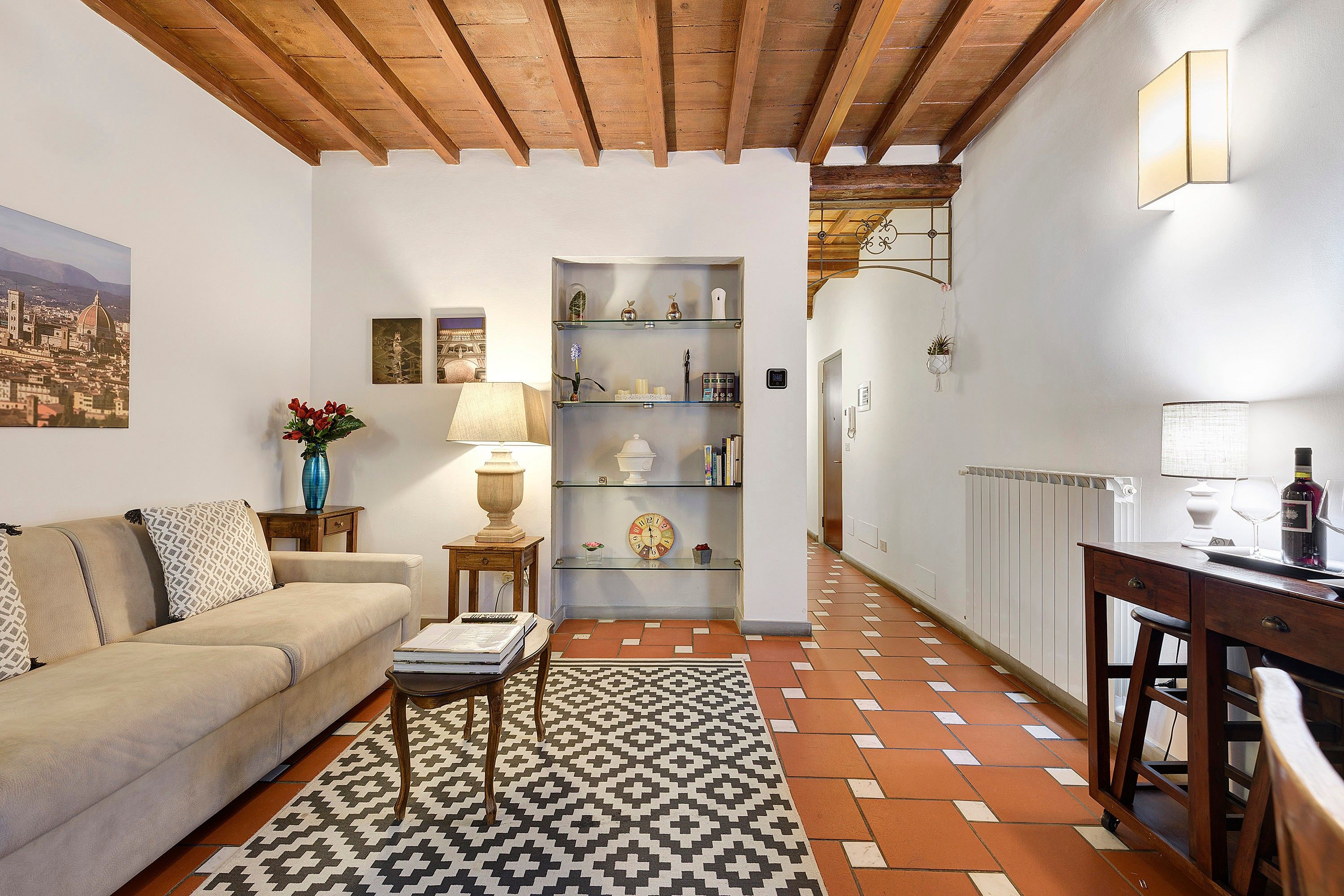 Una sala de estar acogedora con un sofá, una mesa de centro y un tapete estampado.