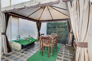 A covered outdoor seating area with a table and chairs, a lantern, and a small decorative box. - Giulia Suite: Florentine Home in the Heart of Florence (Firenze)