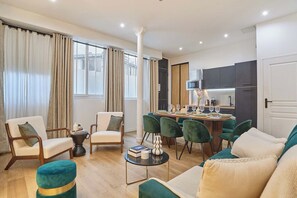 A modern living room with a dining area, a kitchen, and a large window with curtains. - Superb apartment for 8 people - Sacré Coeur (Paris)