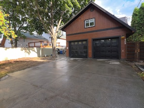 A residential garage with two black garage doors, a wooden exterior, and a visible house number 909. - The Loft in Golden | Downtown · King Bed (Golden)