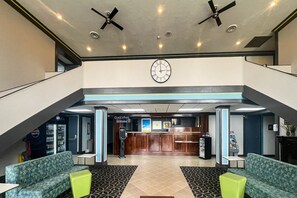En reception, siddeområde og et ur på væggen i lobbyen.