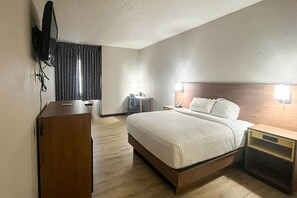 A hotel room with a bed, bedside tables, a desk, a chair, and a television mounted on the wall. - 1 Queen Bed | Non-Smoking, Micfridge (Fremont (OH))