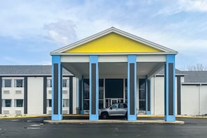 A building with a covered entrance, columns, and a car parked in front. - 1 King Bed | Non-Smoking, Micfridge (Fremont (OH))