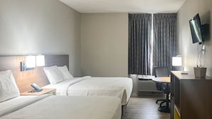 A hotel room with two beds, a desk with a chair, a TV, and a window with curtains. - 2 Queen Beds | Non-Smoking, Micfridge (Fremont (OH))
