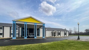 A building with a covered entrance, a parking lot, and a clear sky. - 2 Queen Beds | Non-Smoking, Micfridge (Fremont (OH))