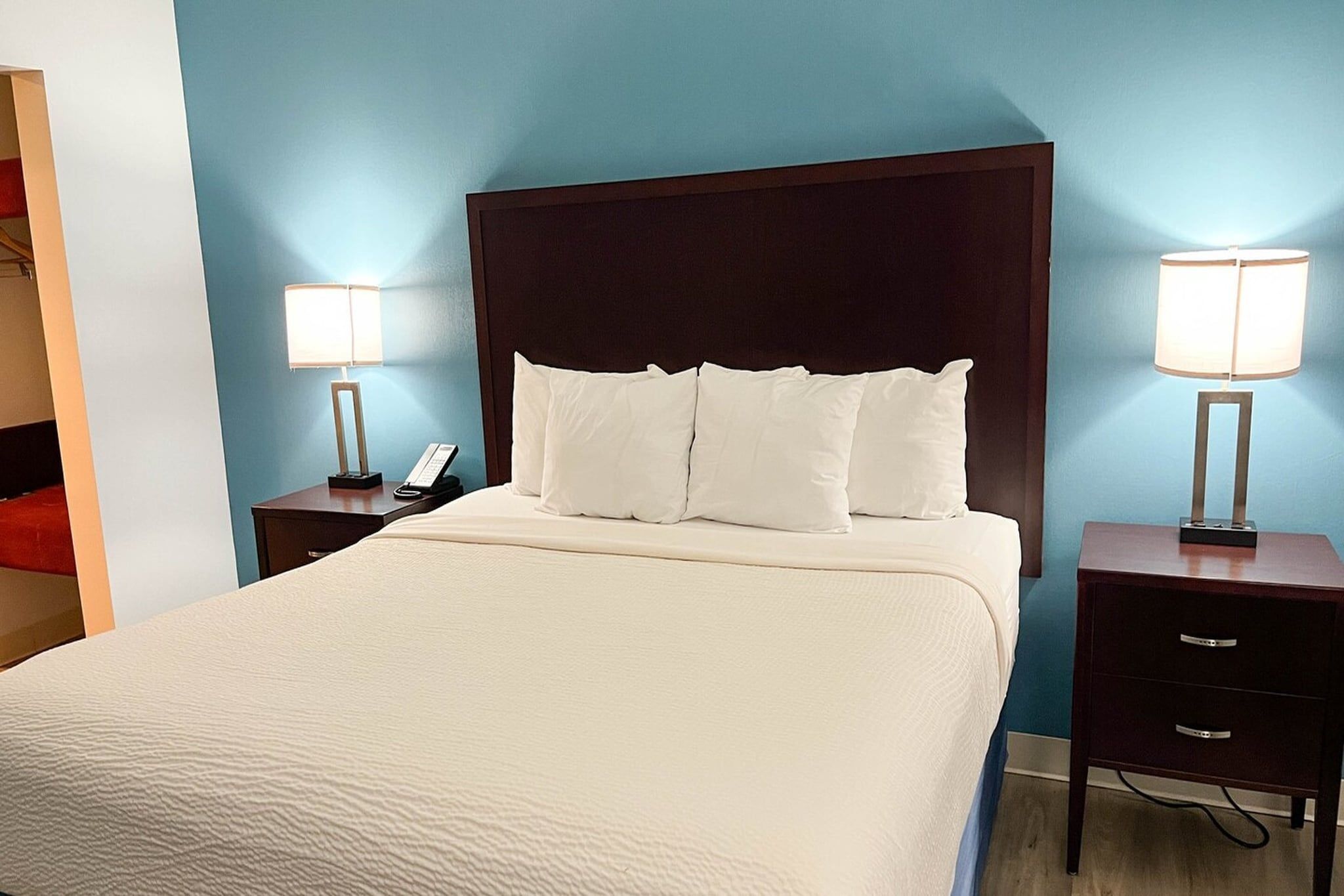 A hotel room with a large bed, two bedside tables with lamps, and a telephone.