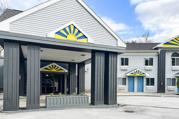 A building with a covered entrance and a distinctive sun design on the roof.