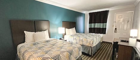 Une chambre d’hôtel avec deux lits, un bureau et une porte.