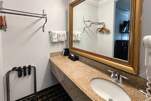 A bathroom with a sink, mirror, towel rack, and a towel dispenser. - 1 King Bed | Non-Smoking, Micfridge (Lafayette LA)