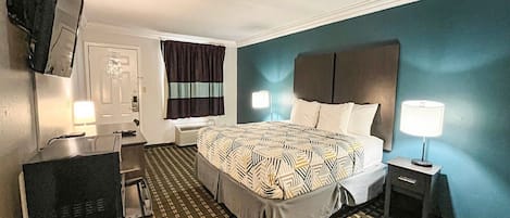 A hotel room with a bed, bedside lamps, a desk, and a chair.
