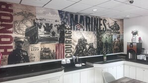L’intérieur d’un restaurant est orné d’une grande fresque représentant des scènes militaires, ainsi que des inscriptions « MARINES » et « Courage ».