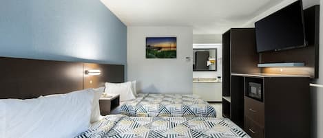 A hotel room with a bed, bedside tables, a TV, a mirror, and a painting on the wall.
