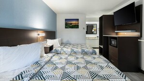 Ein Hotelzimmer mit Bett, Nachttischen, Fernseher, Spiegel und einem Bild an der Wand.