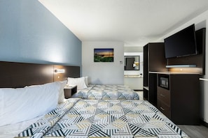 Quarto de hotel com cama, mesas de cabeceira, televisão, espelho e um quadro na parede.