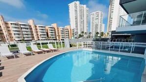 Une piscine sur le toit, offrant une vue sur les gratte-ciel en arrière-plan.