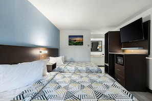 Ein Hotelzimmer mit einem Bett, einem Nachttisch, einem Fernseher, einem Spiegel und einem Bild an der Wand.