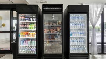 Trois distributeurs automatiques de boissons proposent une variété de boissons et d’en-cas.