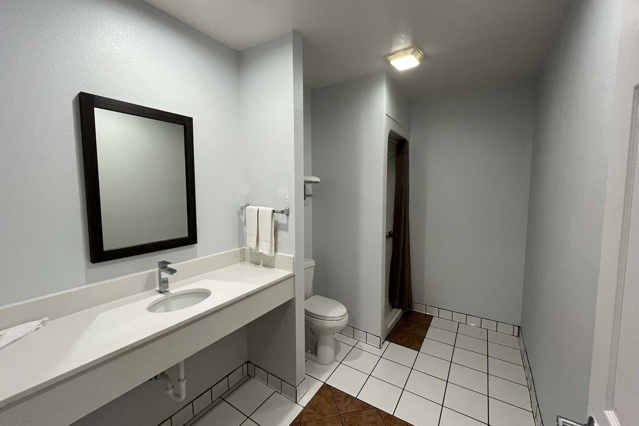 A bathroom with a white sink, a mirror, and a toilet.
