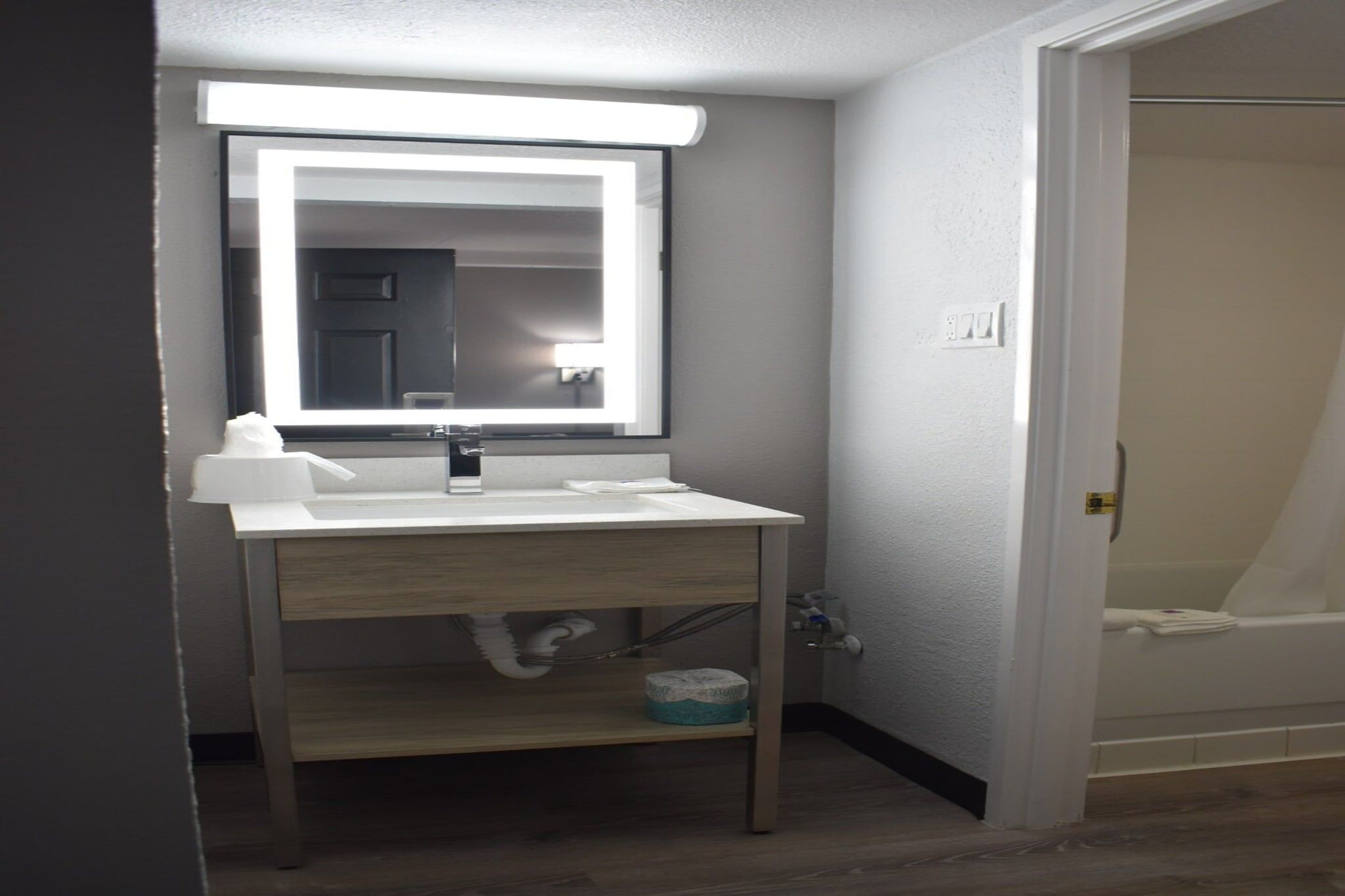 Une salle de bain avec un lavabo blanc, un miroir et un porte-serviettes.