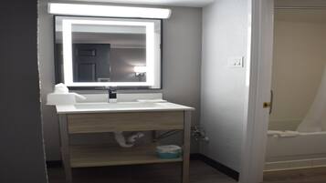 Une salle de bain avec un lavabo blanc, un miroir et un porte-serviettes.