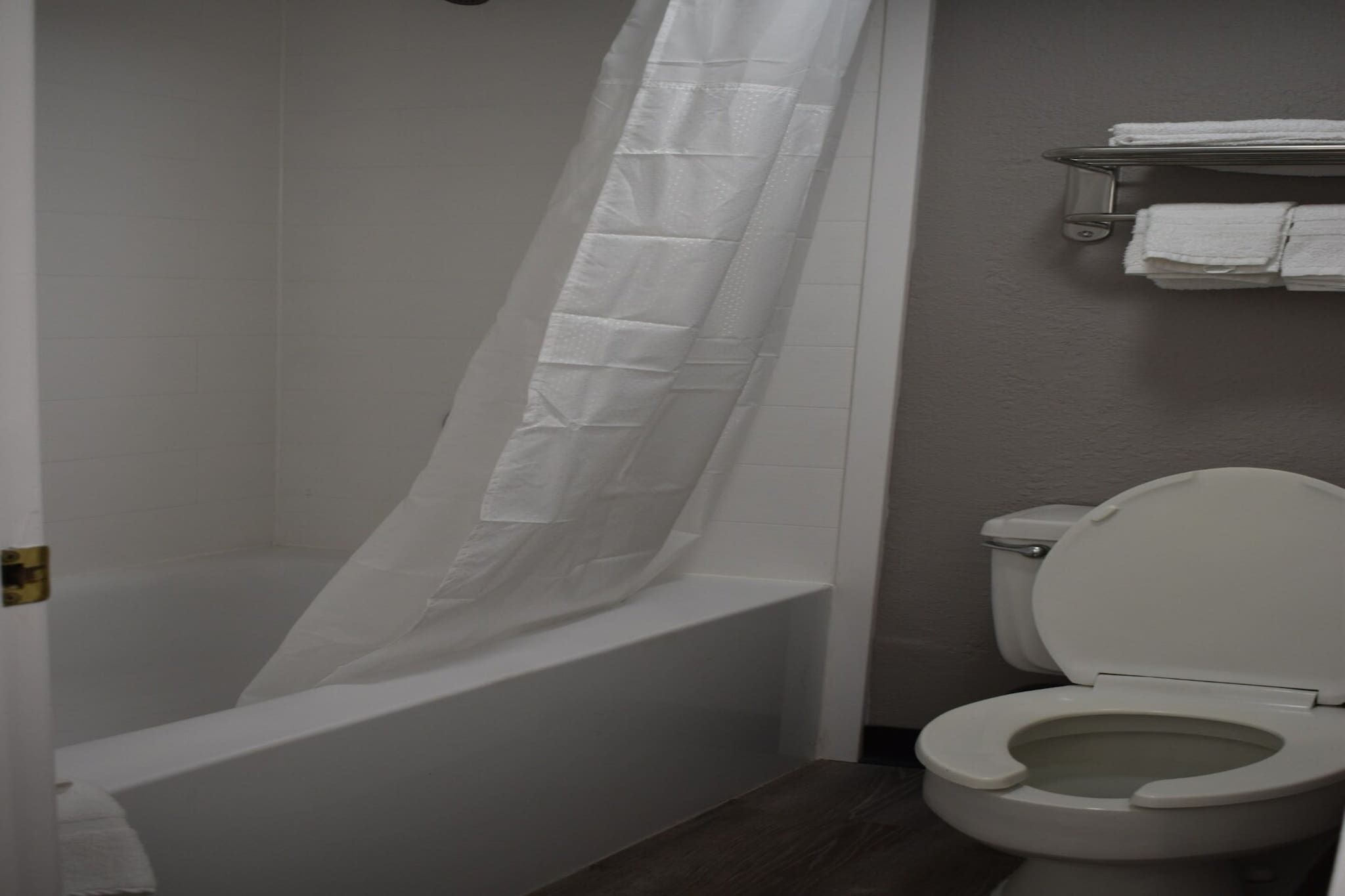 Une salle de bain avec une baignoire, des toilettes et un rideau de douche.