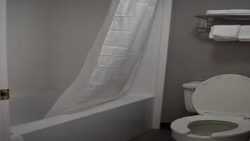 Une salle de bain avec une baignoire, des toilettes et un rideau de douche.