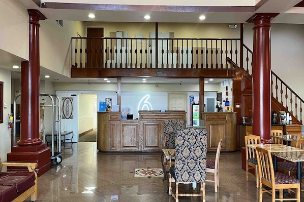 A spacious lobby with a reception desk, a staircase, and a dining area with wooden chairs and a patterned tablecloth. - 2 Queen Beds | Non-Smoking, Micfridge (Tucson AZ)