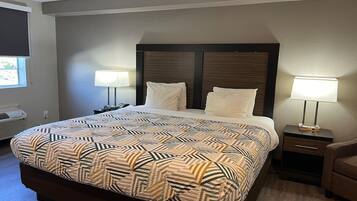A hotel room with a large bed, two bedside tables, a wall-mounted TV, and a window.