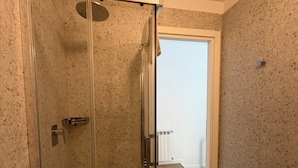 A glass-enclosed shower stall with a white floor, a towel rack, and a visible toilet paper holder. - Luciano King's Guest House (Roma)