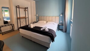 A modern bedroom with a bed, a wardrobe, a mirror, and a window. - Luciano King's Guest House (Roma)