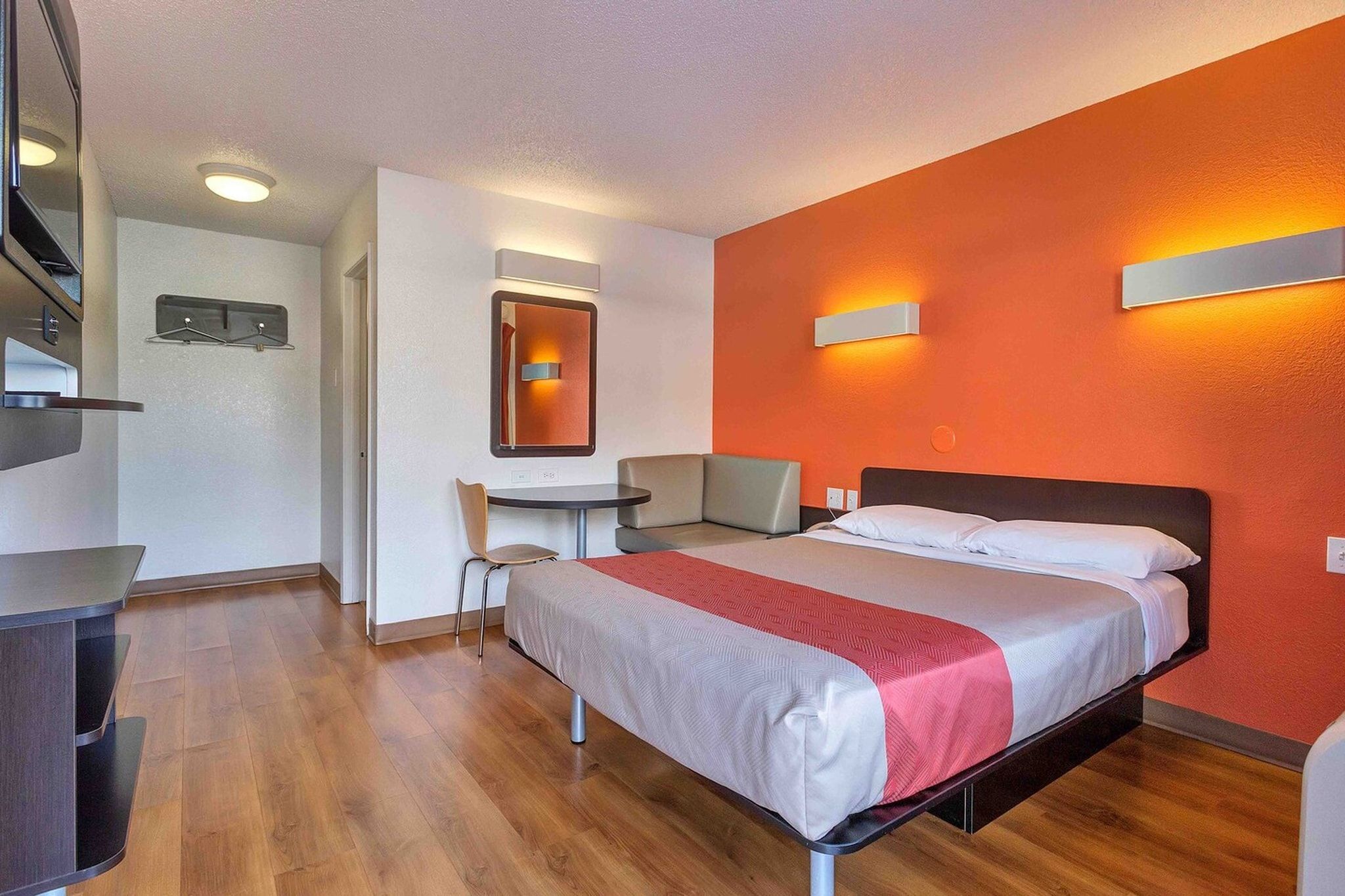 A hotel room with a bed, a desk, and a chair.