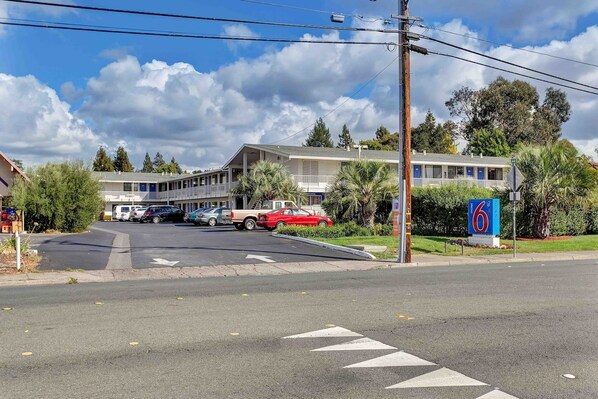 A motel with a parking lot, a red car parked in front, and a signboard. - 1 Full Bed|Mobility|RI Shwr|Micfridge (Santa Rosa CA)