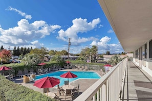 A pool area with lounge chairs and umbrellas, overlooking a residential neighborhood. - 1 Full Bed|Mobility|RI Shwr|Micfridge (Santa Rosa CA)