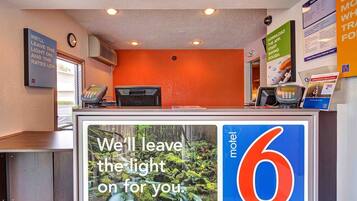 A motel reception desk with a large digital display advertising the motel's services.