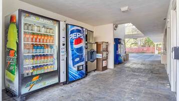 A corridor with vending machines, including a Gatorade cooler and a Pepsi cooler, and a newspaper dispenser.