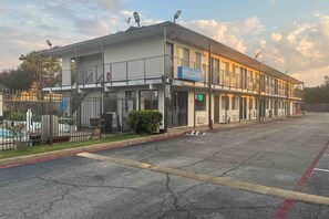 Un edificio de dos pisos con un letrero que dice 'Bienvenido', un letrero que indica 'Recepción' y un letrero de 'Límite de velocidad 0'.