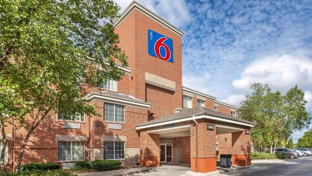 Un edificio de ladrillo con un letrero azul y rojo que indica un motel.
