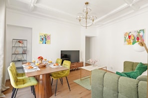 A modern living room with a dining area, a flat-screen TV, and artwork on the walls. - Stay Near Sorbonne & Luxembourg Garden (Paris)