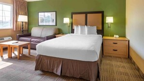 Ein Hotelzimmer mit Bett, Sofa, Schreibtisch und Nachttisch.
