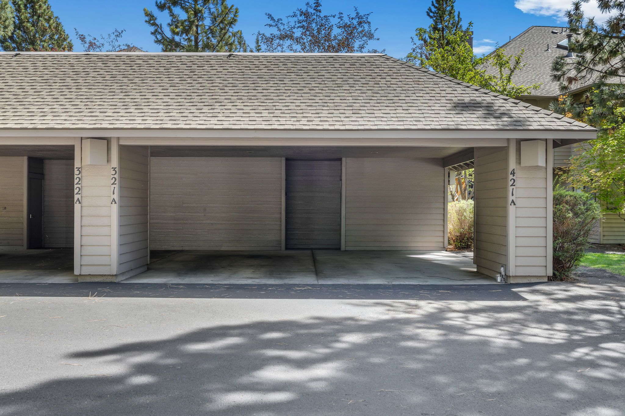Un bâtiment d’un seul étage, doté d’un toit plat, de trois portes de garage et d’une allée en béton.