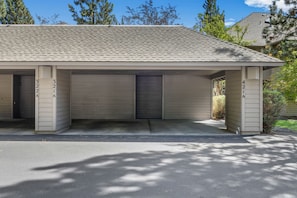 A single-story building with a flat roof, three garage doors, and a concrete driveway. - Mt Bachelor Village 321 | Hot Tub | Scenic Views (Bend)