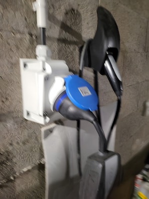 A power outlet with a blue cover and a white device attached to it.