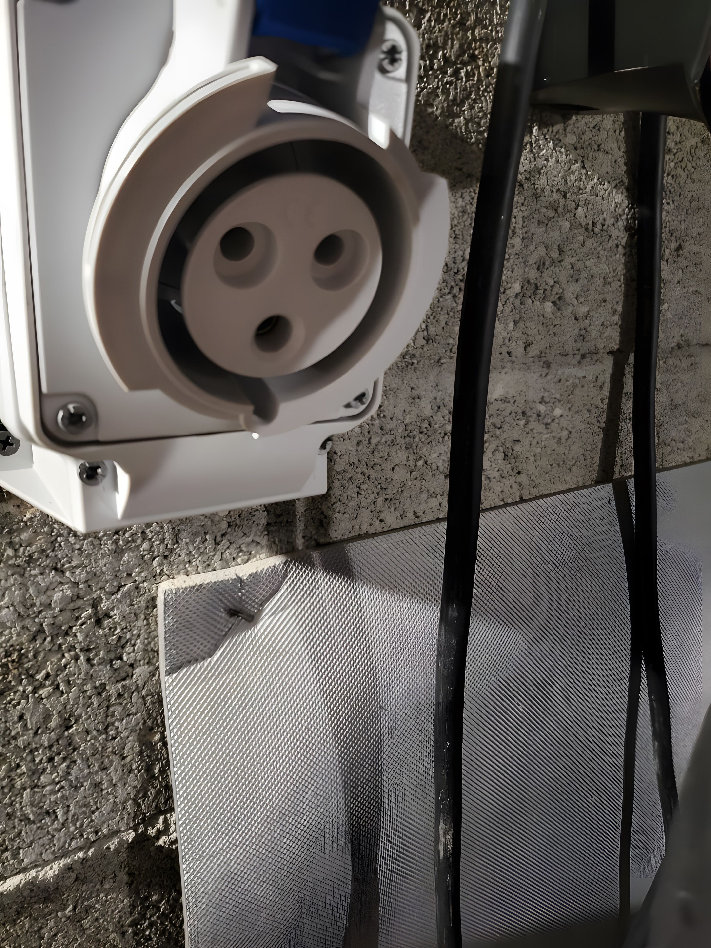 Un primo piano di un oggetto bianco con un componente circolare, forse parte di una macchina o di un'attrezzatura, su uno sfondo strutturato.