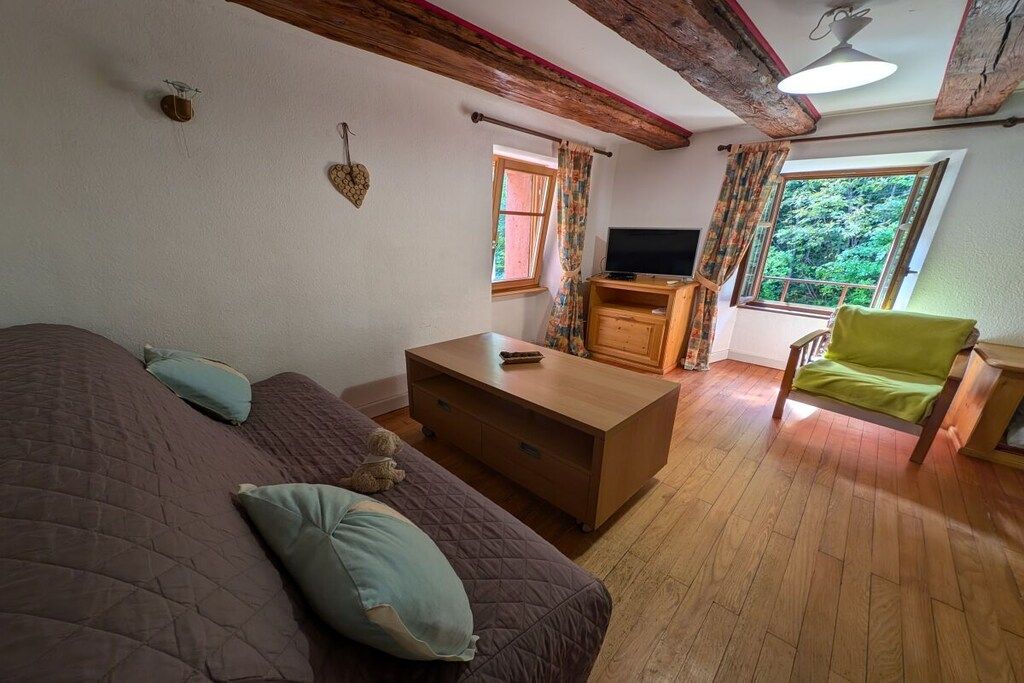 Une chambre à coucher avec un lit, une commode en bois, un téléviseur et une chaise.