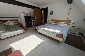 Ein Schlafzimmer mit zwei Betten, einem Schminktisch, einem Schreibtisch und einem Stuhl.