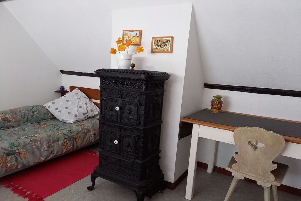 Ein Schlafzimmer mit einem Bett, einem Schminktisch, einem Schreibtisch und einem Stuhl.