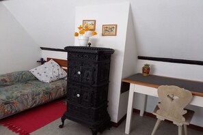 Ein Schlafzimmer mit einem Bett, einem Schminktisch, einem Schreibtisch und einem Stuhl.