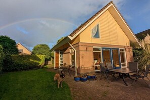 A house with a brick exterior, a large glass door, and a patio with outdoor furniture. - Holiday home with 1 bedroom (Medemblik)